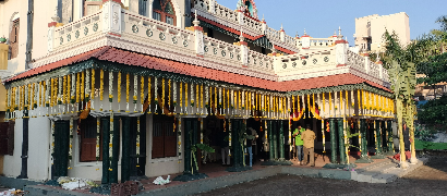 Traditional house decorated with yellow flower garlands hanging from the roofline, ready for a festive or ceremonial event.