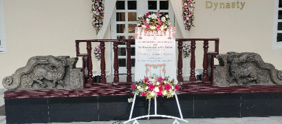 Name board decorated with fresh flowers and greenery, perfect for welcoming guests to an event.